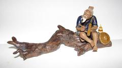 China Man sitting on a log Figurine
